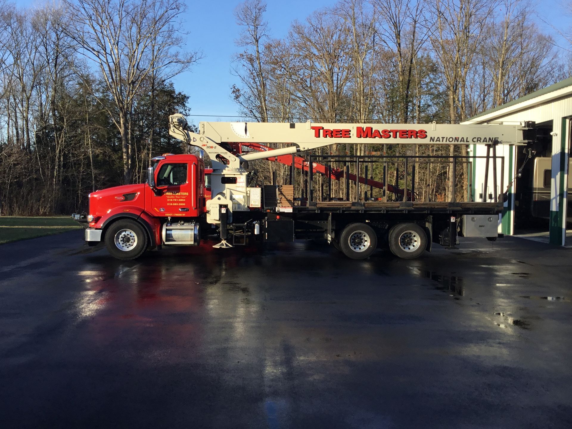 A red and white tree masters truck is parked in a parking lot