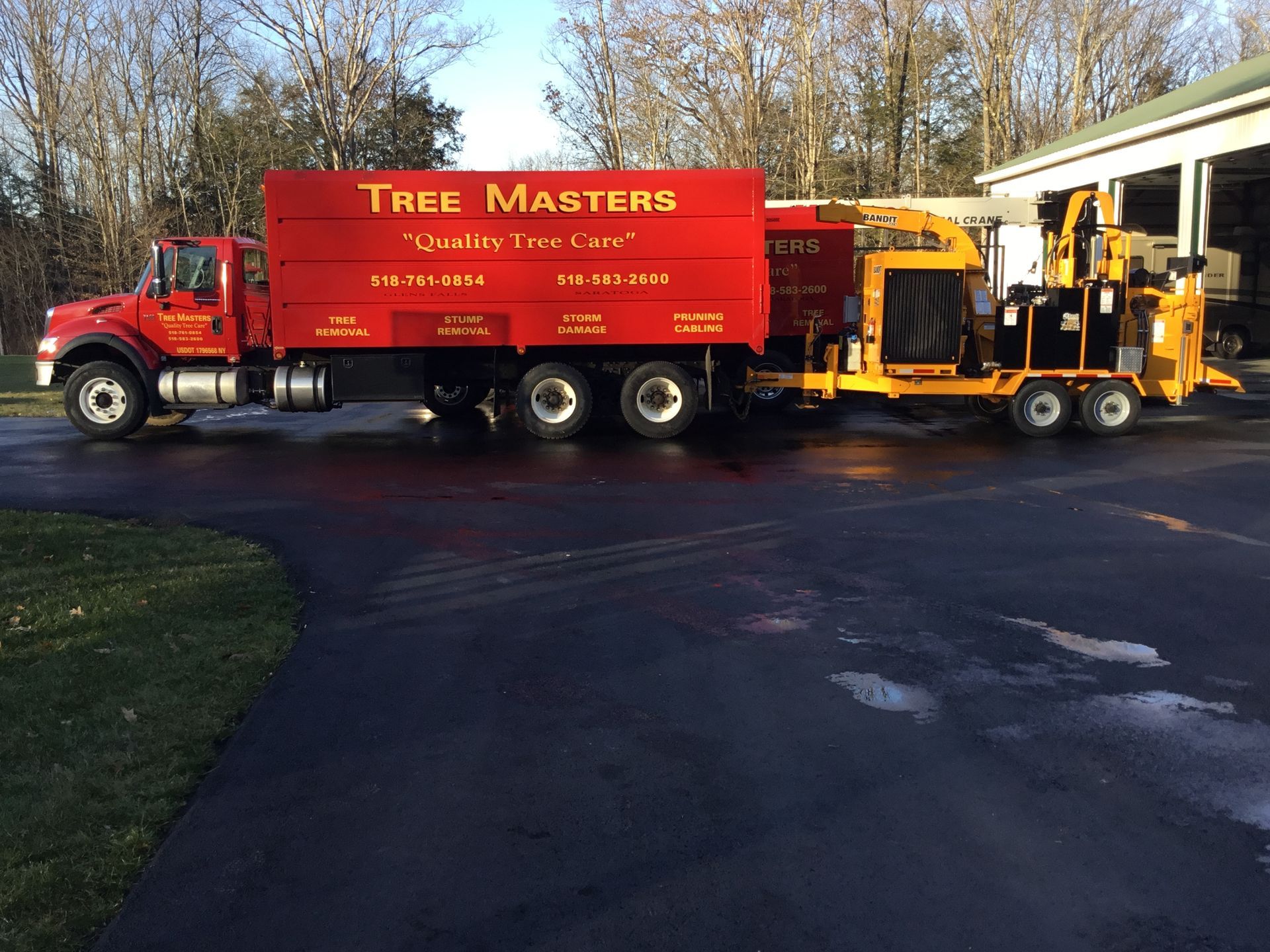 A red truck with a yellow trailer attached to it is parked in a driveway