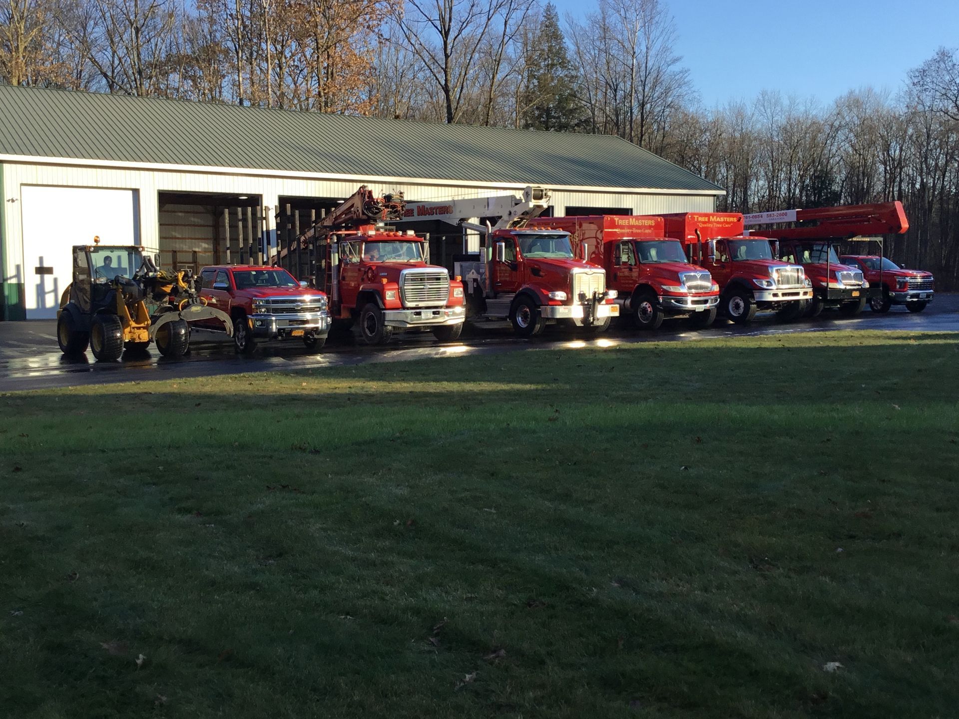 A row of red trucks are parked in front of a building