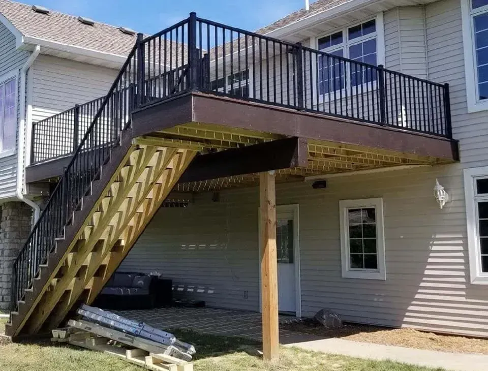 A house with a deck and stairs leading up to it.