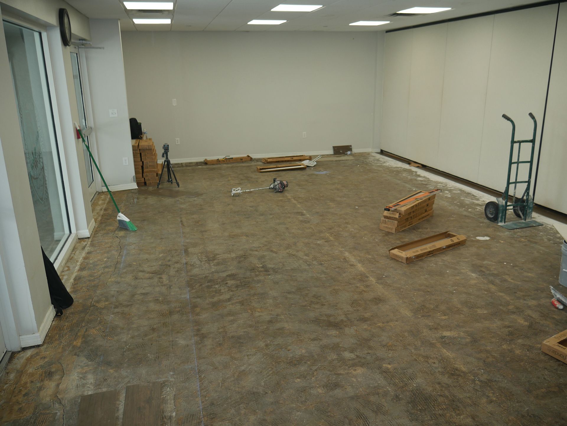 A large empty room with a cart and boxes on the floor