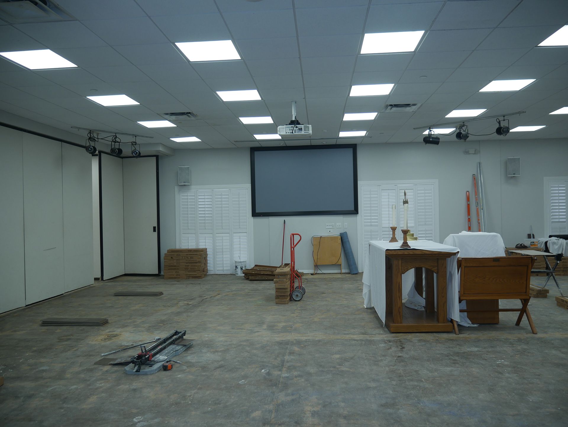 An empty room with a large screen on the wall
