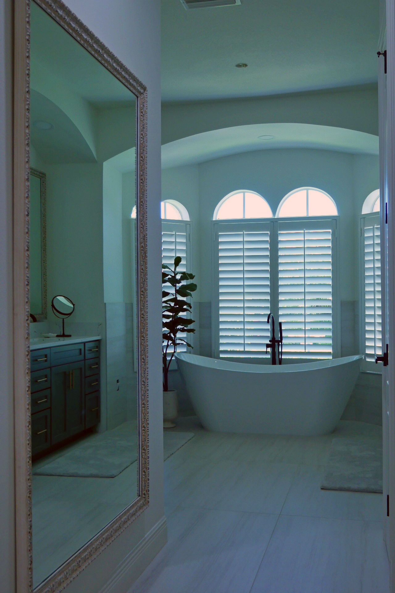 A bathroom with a large mirror and a tub