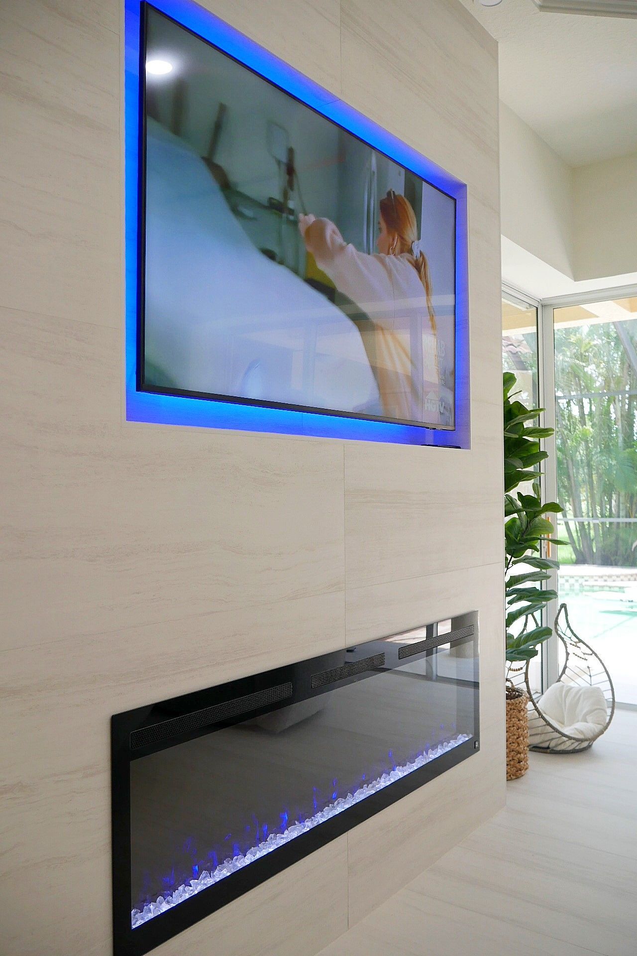 A flat screen TV is mounted on a wall above a fireplace