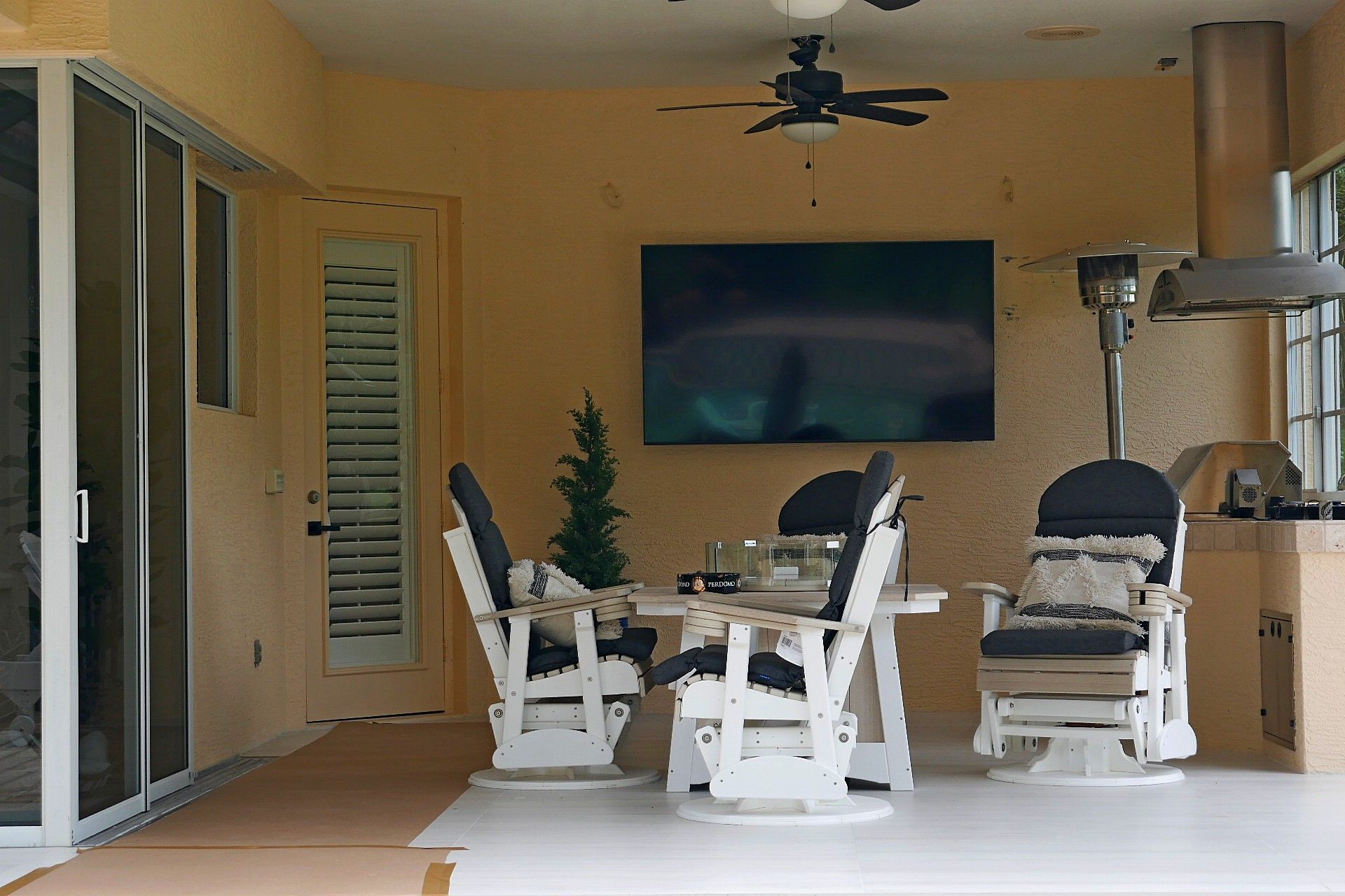 A patio with a table and chairs and a flat screen TV