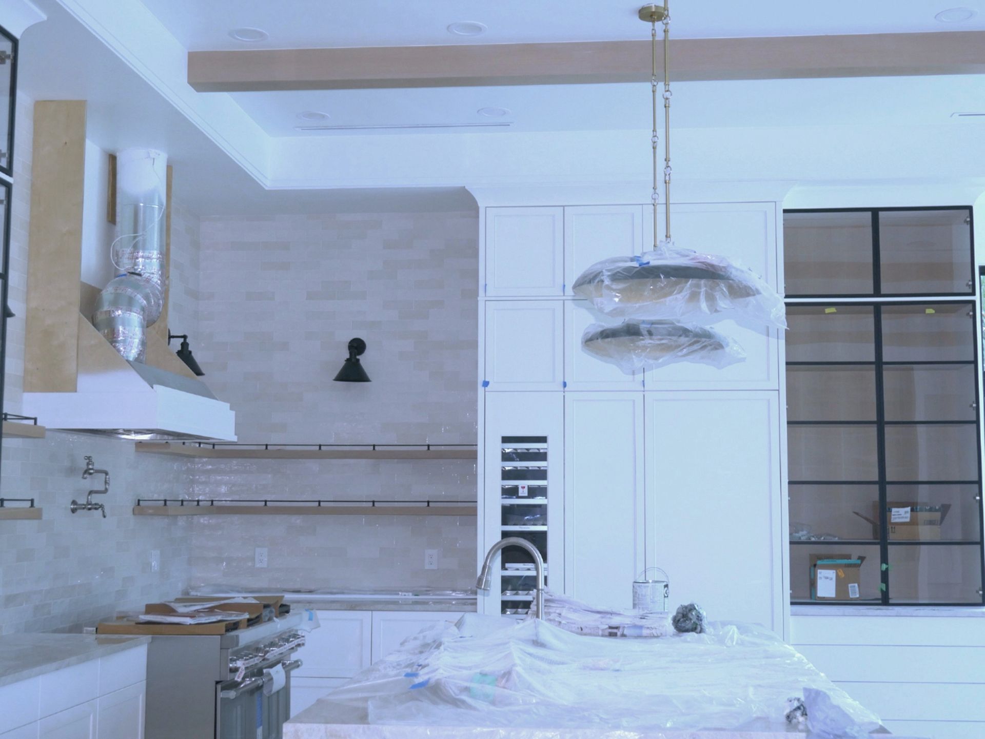 A kitchen with white cabinets, stainless steel appliances, and a large island