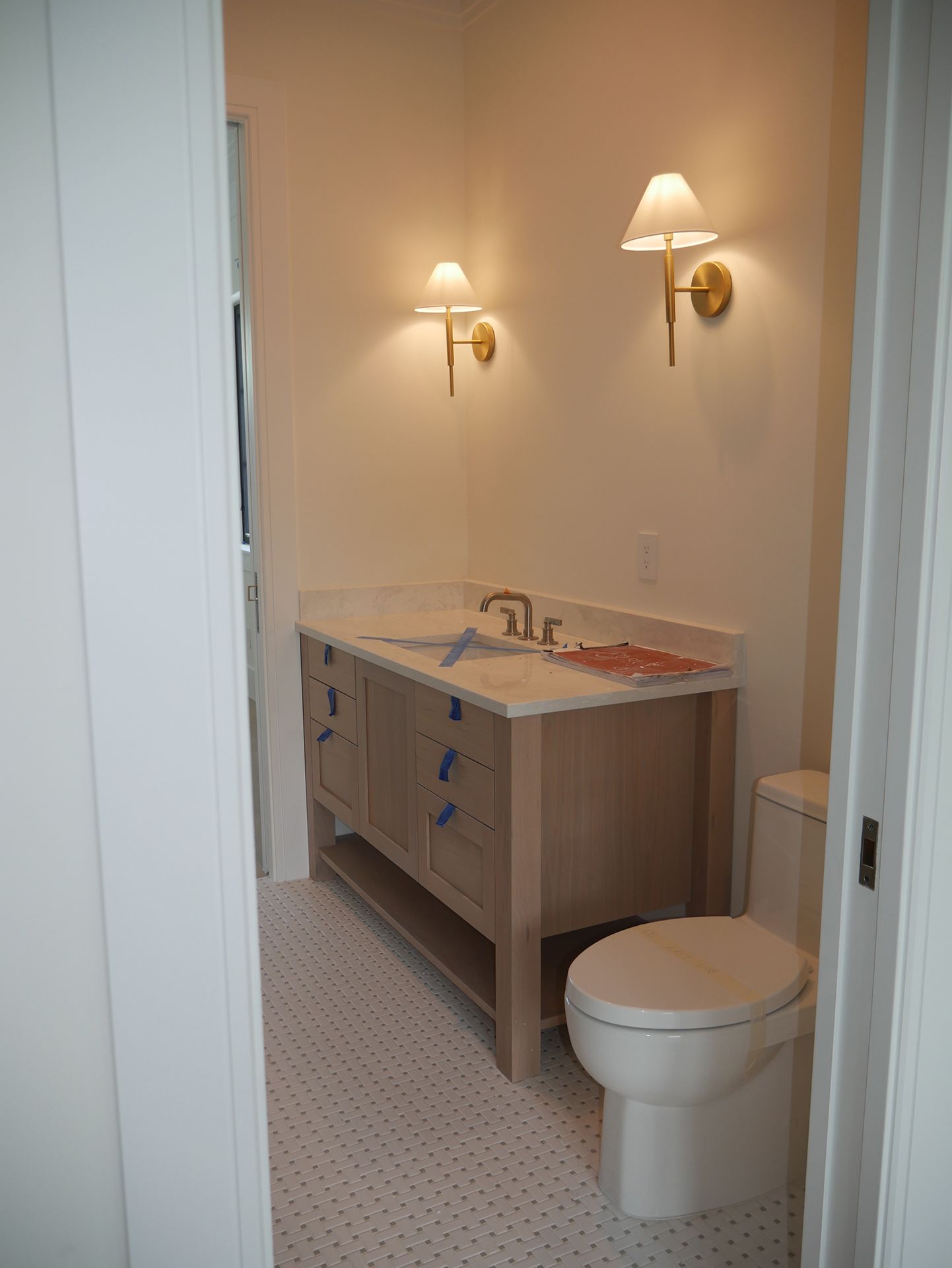 A bathroom with a toilet, sink, and two lights on the wall
