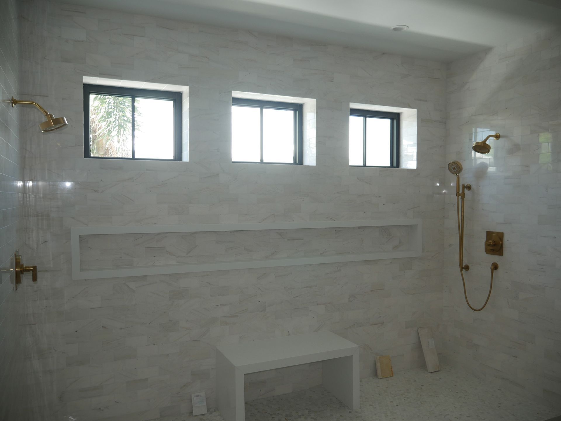 A bathroom with a walk in shower and a bench