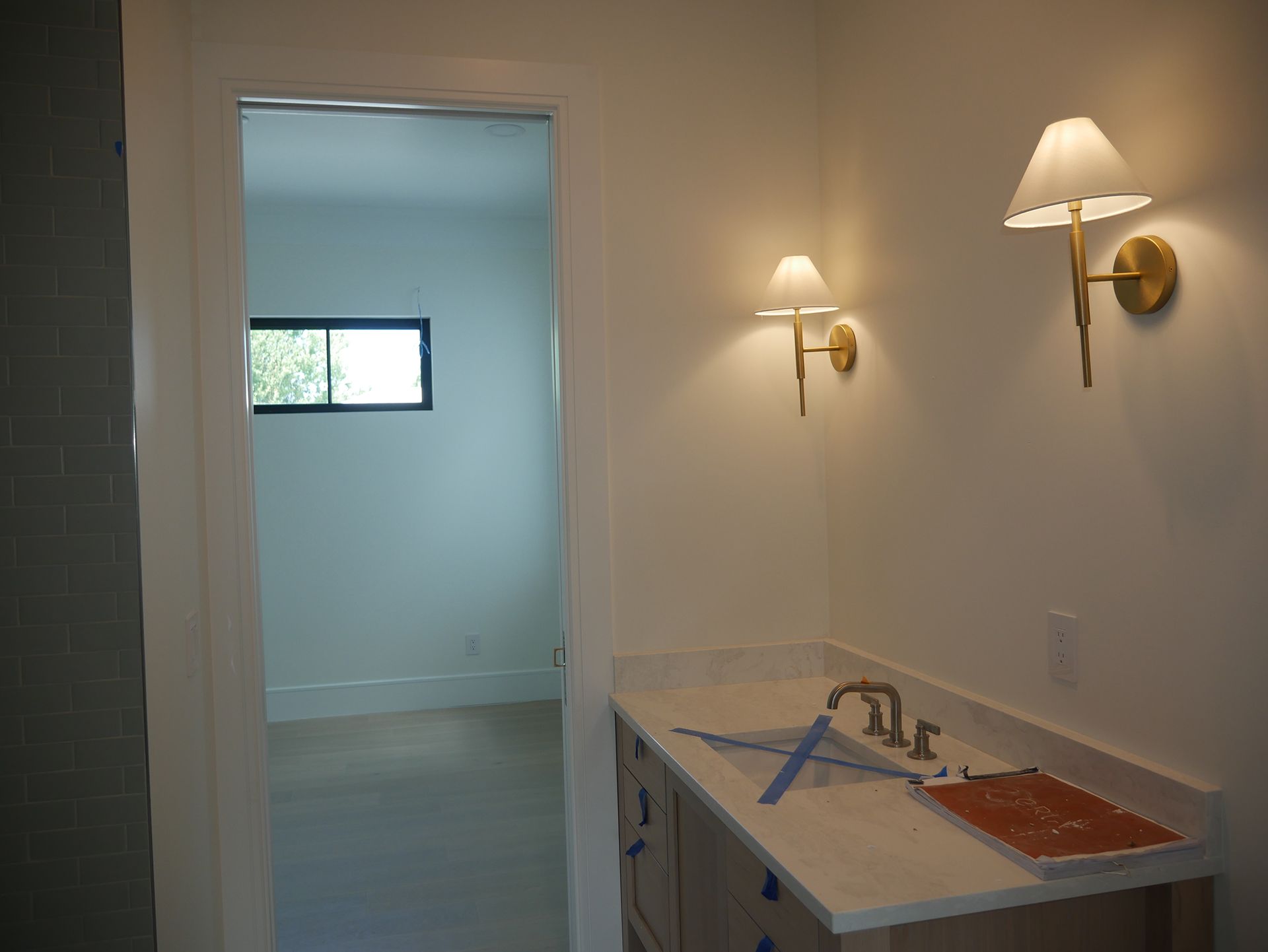 A bathroom with a sink and two lights on the wall