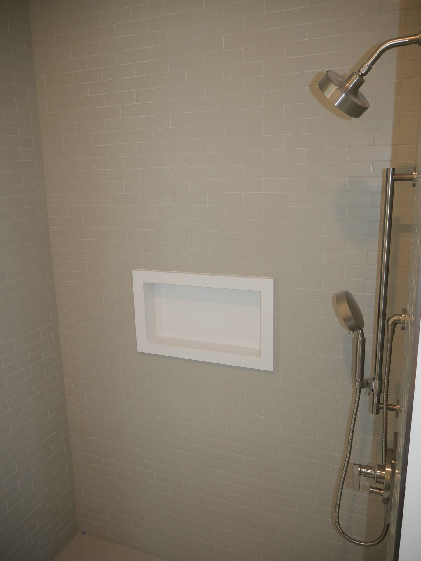 A shower with a soap dish on the wall