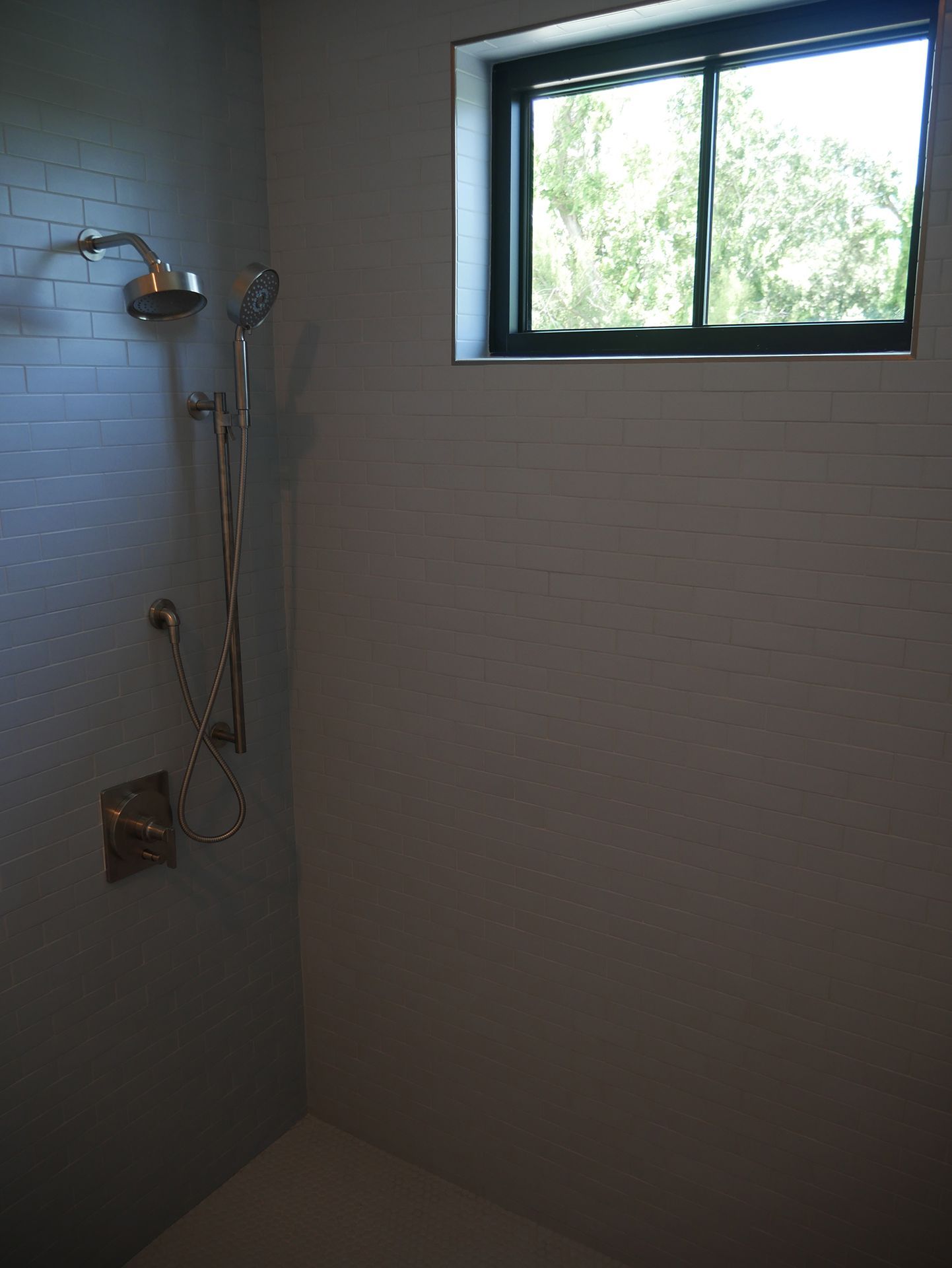 A shower with a window and a shower head