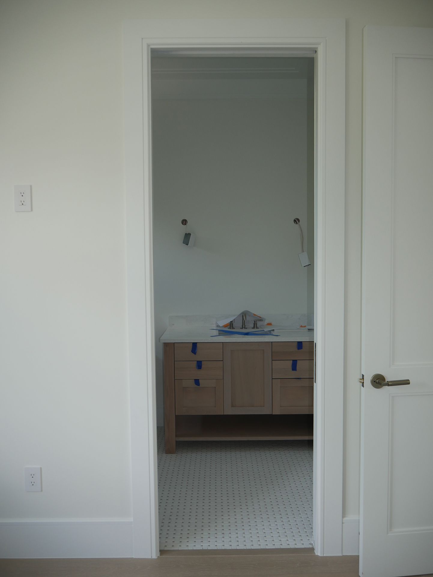 The door is open to a bathroom with a sink and cabinets