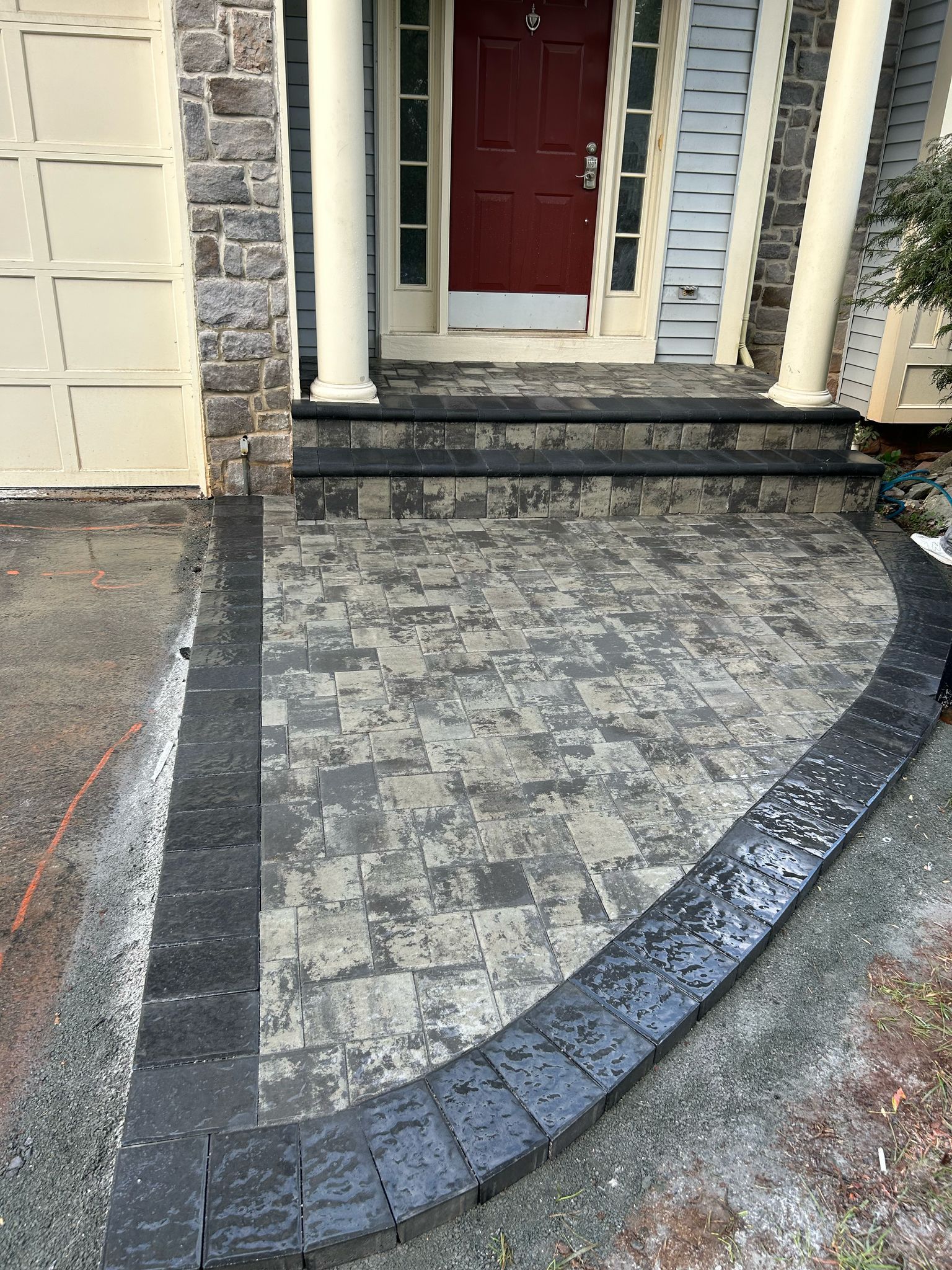 A brick walkway leading to the front door of a house.