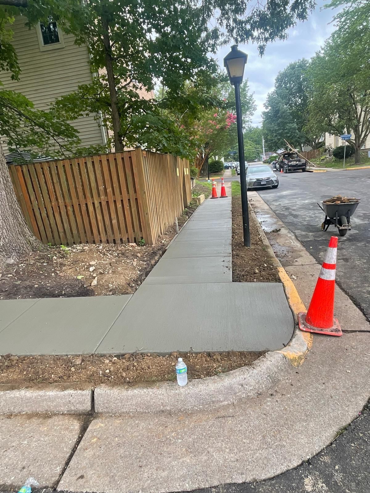 A concrete sidewalk is being built on the side of a street.