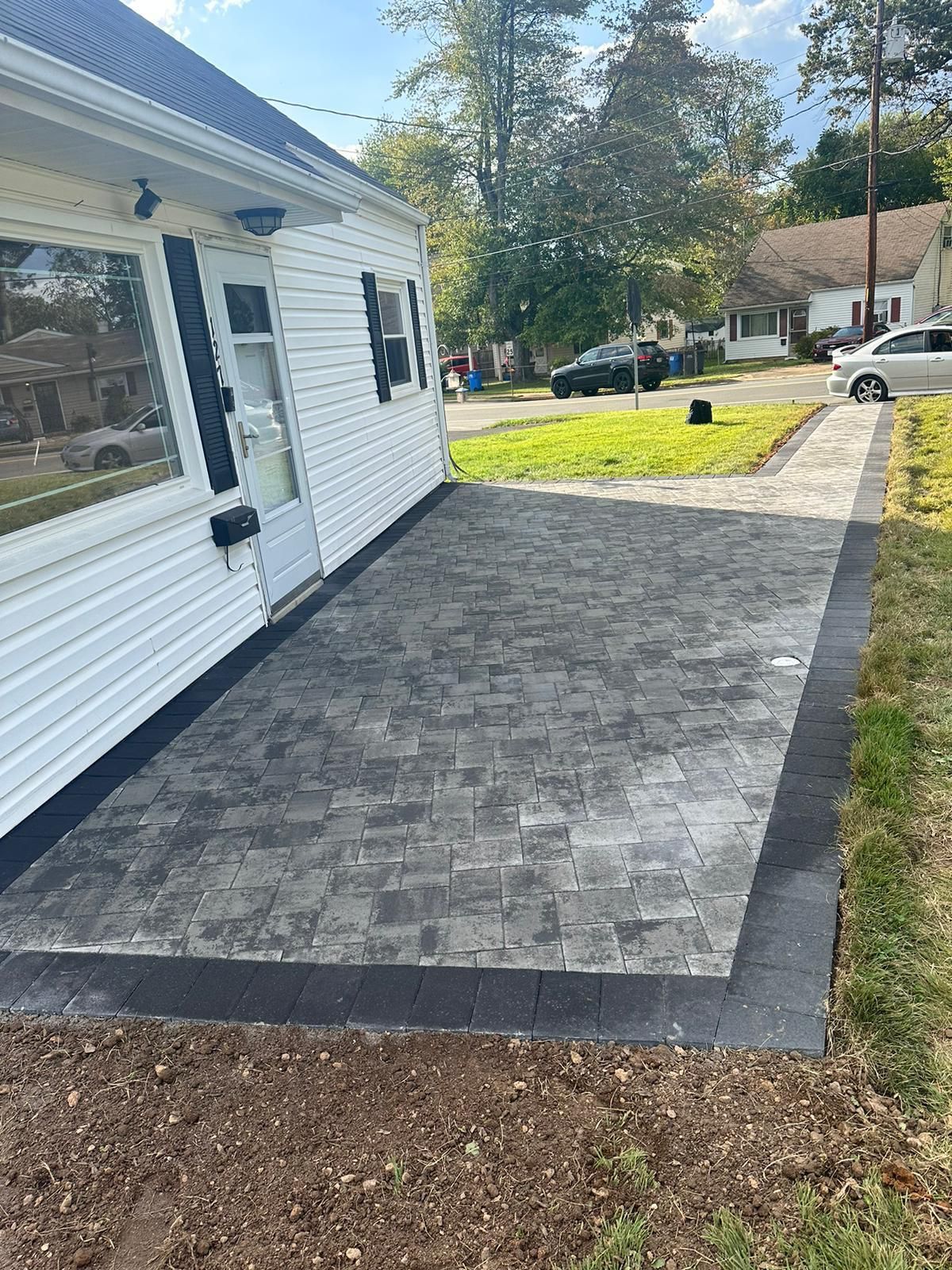 A white house with a concrete patio in front of it.