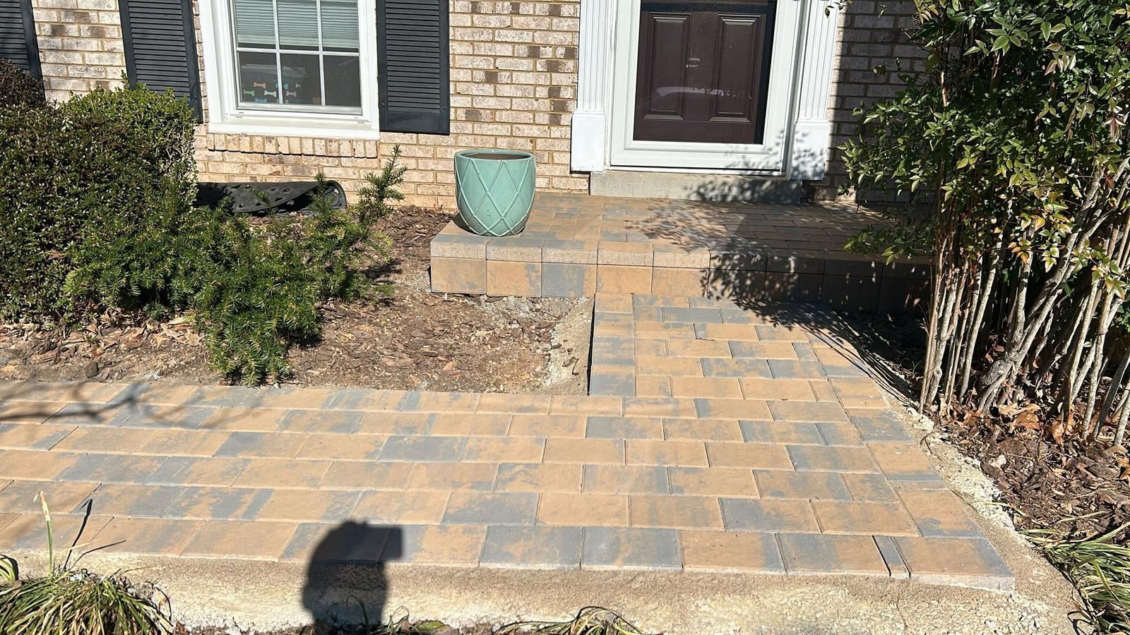 A brick walkway leading to the front door of a house.