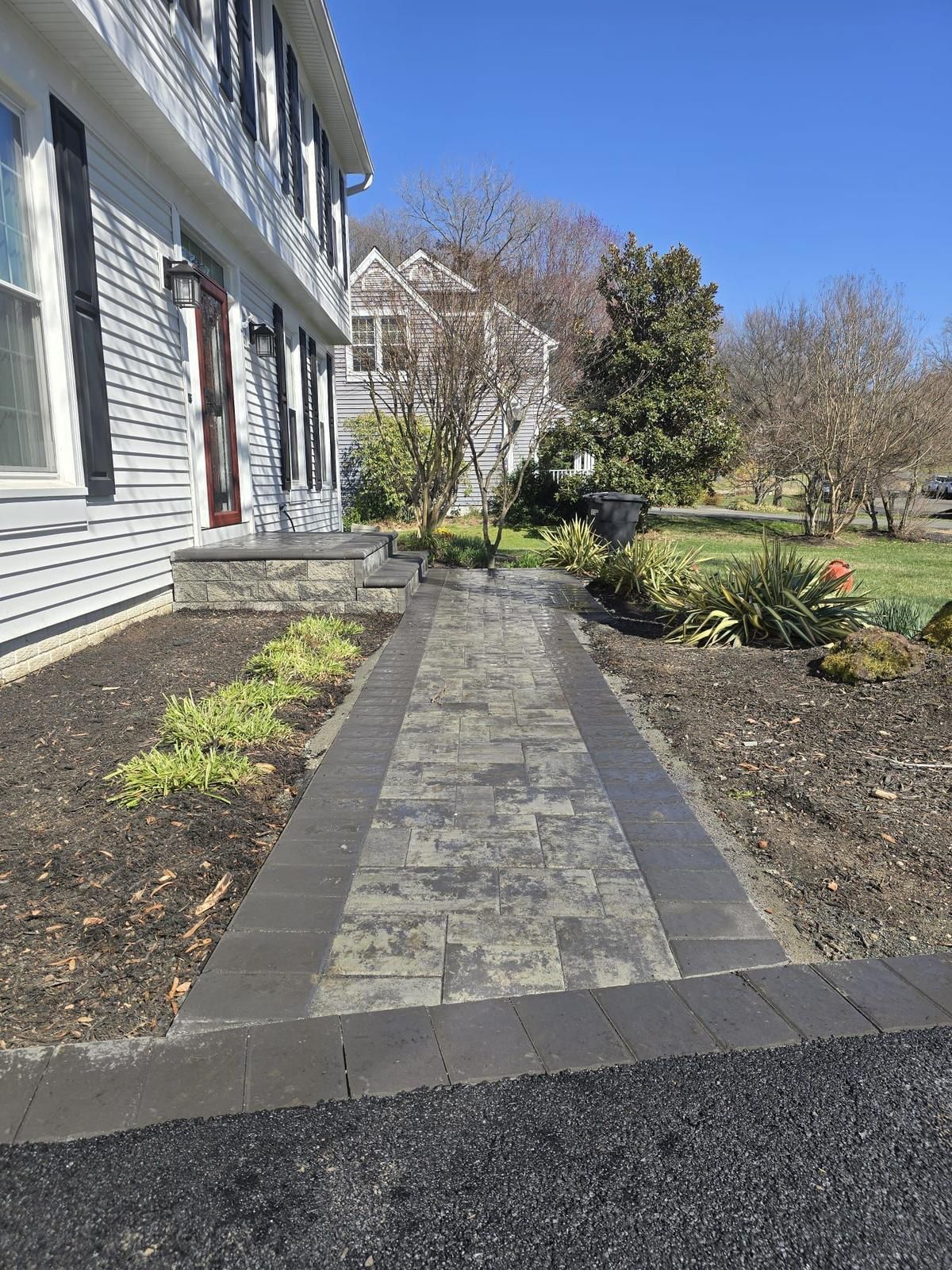 There is a walkway leading to the front of a house.