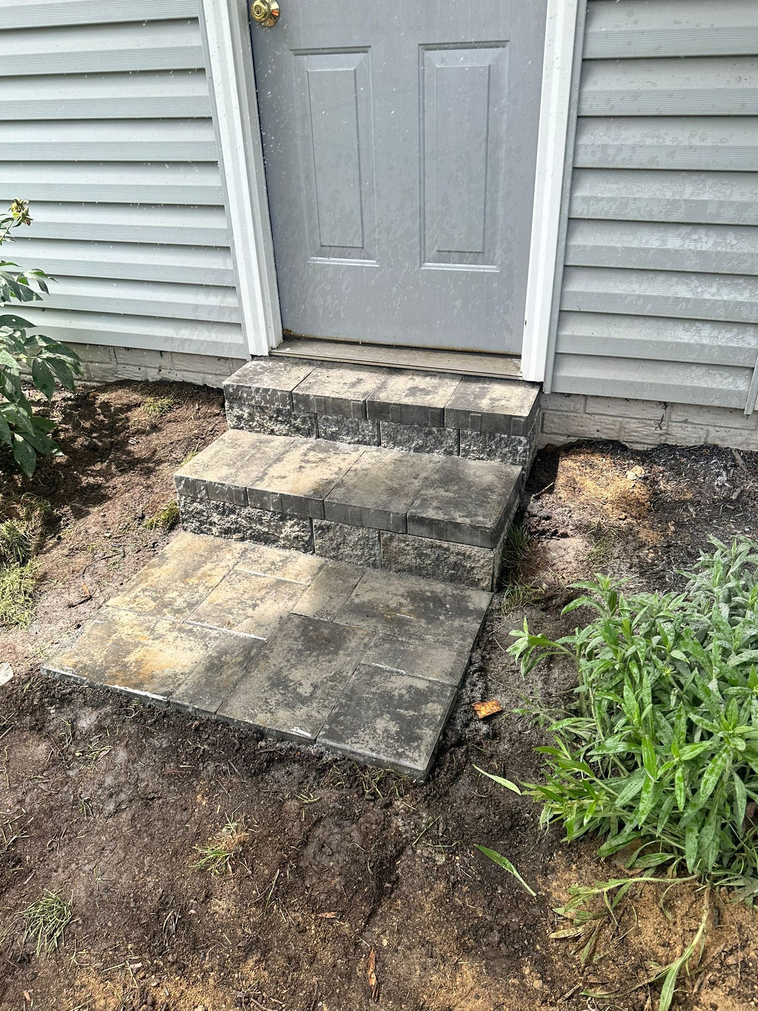 A set of concrete steps leading up to a door of a house.