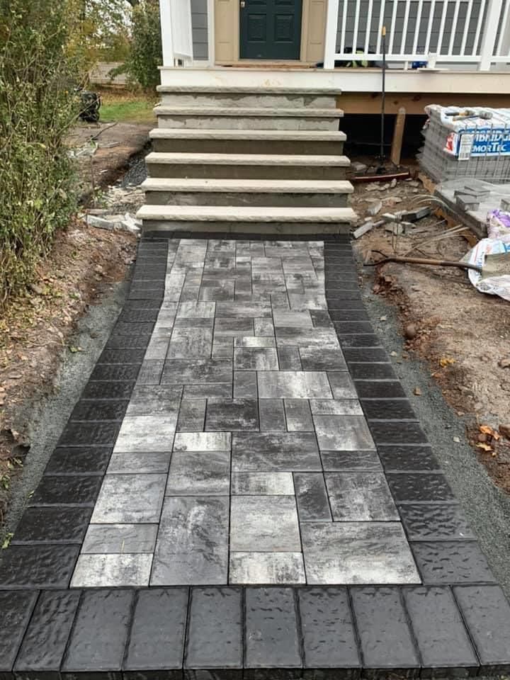 A black and white walkway with stairs leading to a house.
