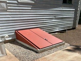 A red door is sitting on the side of a house.