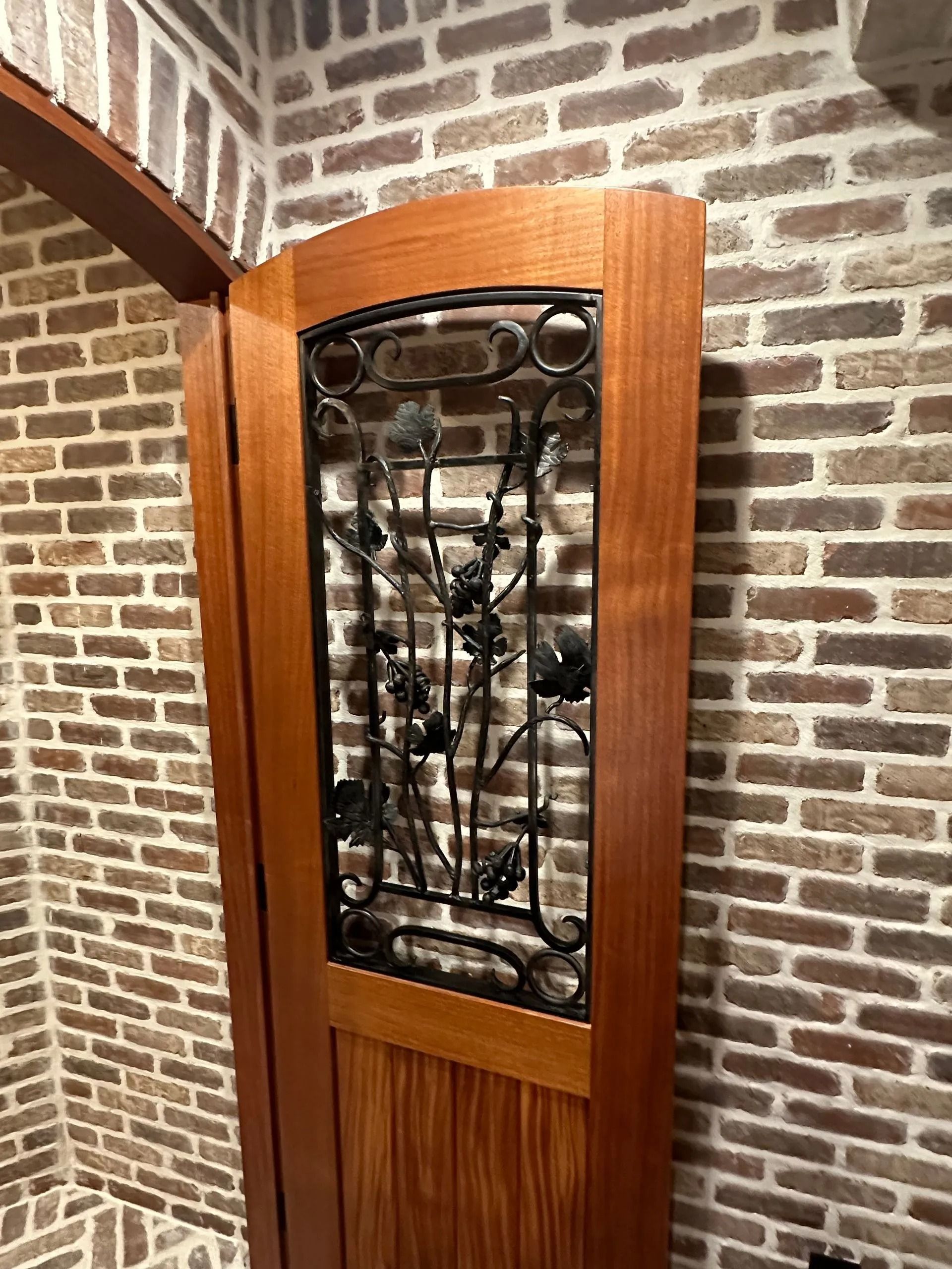 Wood-framed stained-glass window set into a brick wall corner
