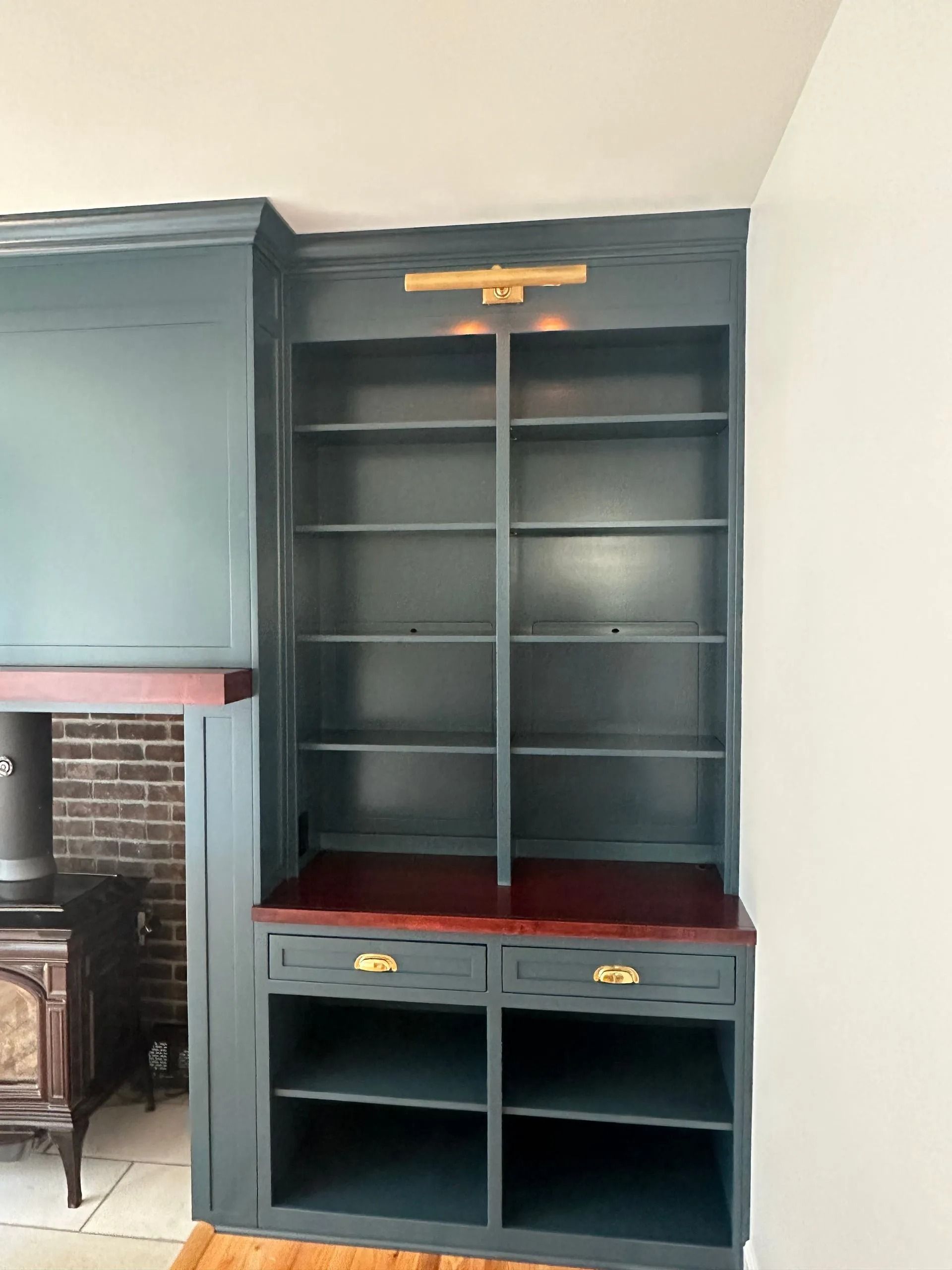 Blue built-in shelving unit with red desktop and open cubbies beside a fireplace.
