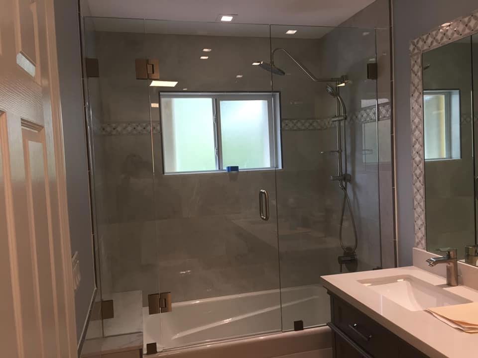 A bathroom with a tub, sink, and shower with a glass door.