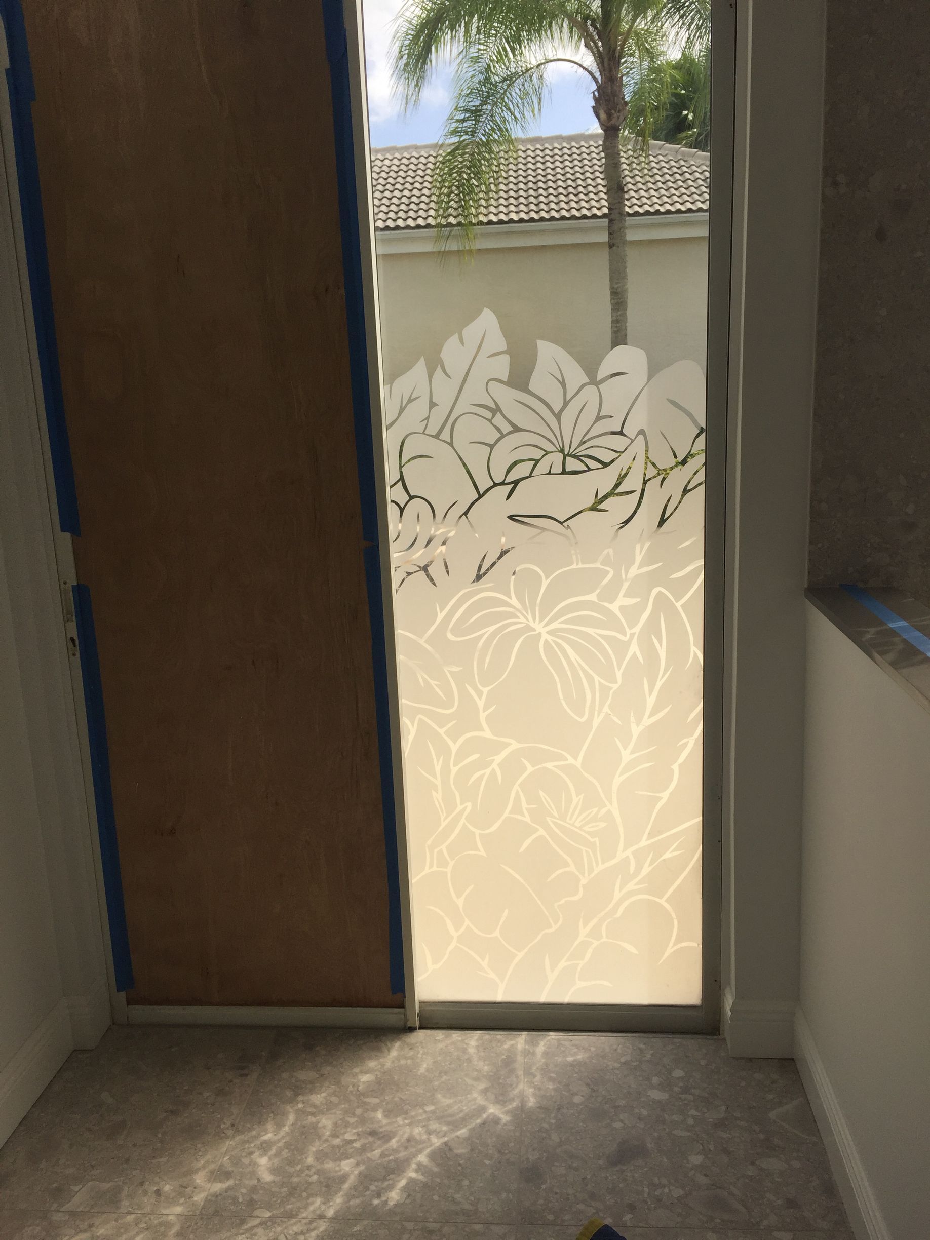 A room with a door and a window with a stained glass design.