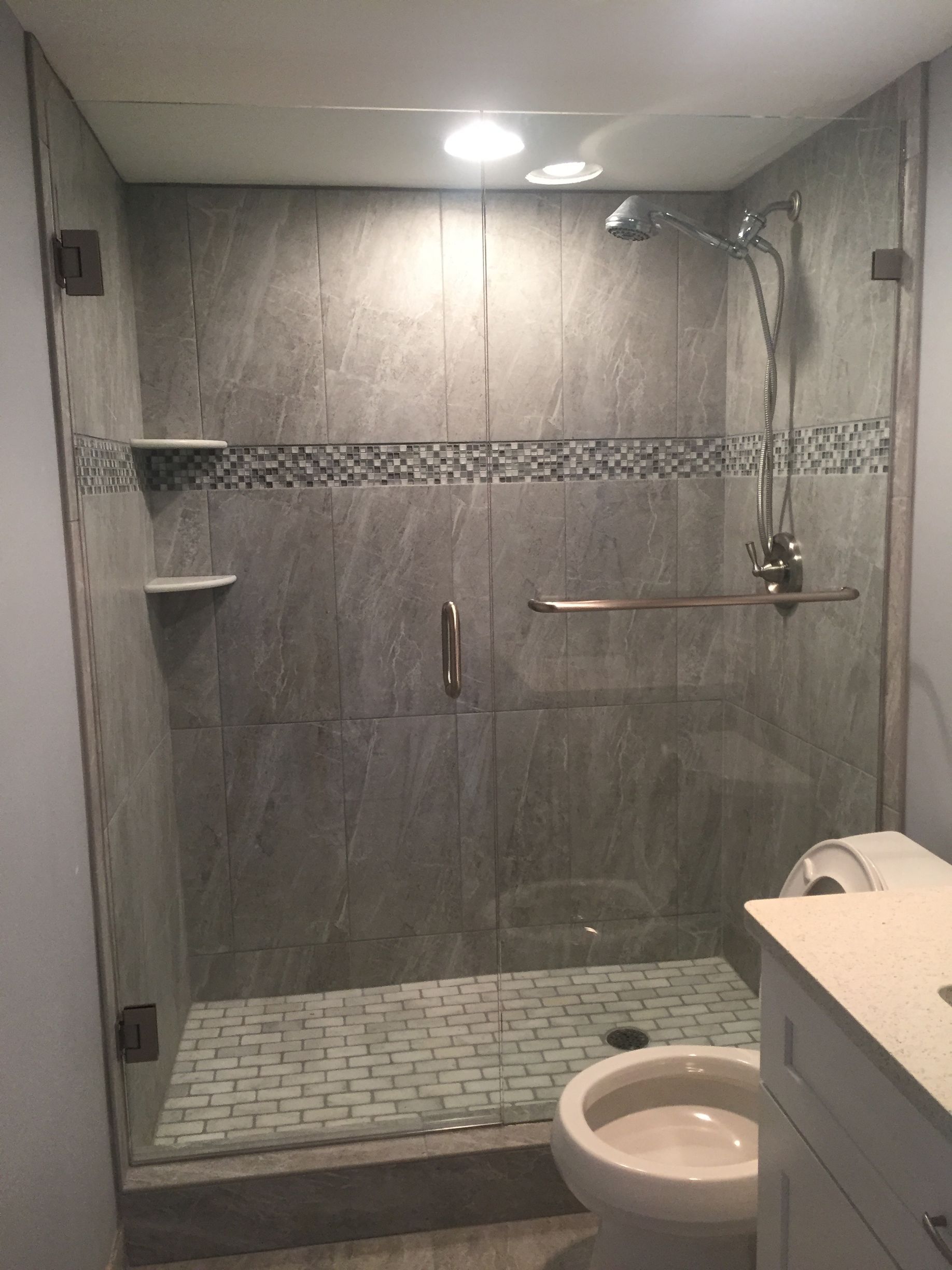 A bathroom with a toilet and a shower with a glass door.