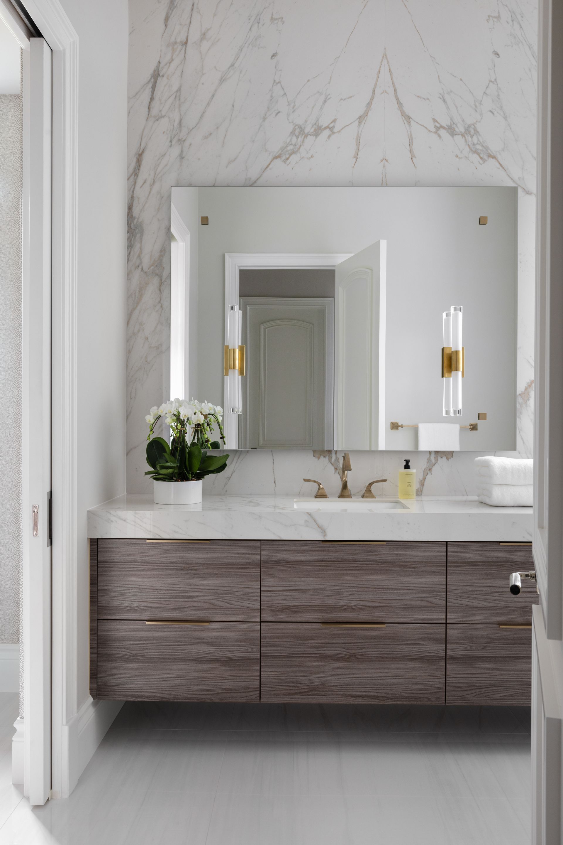 A bathroom with a large mirror and a sink.