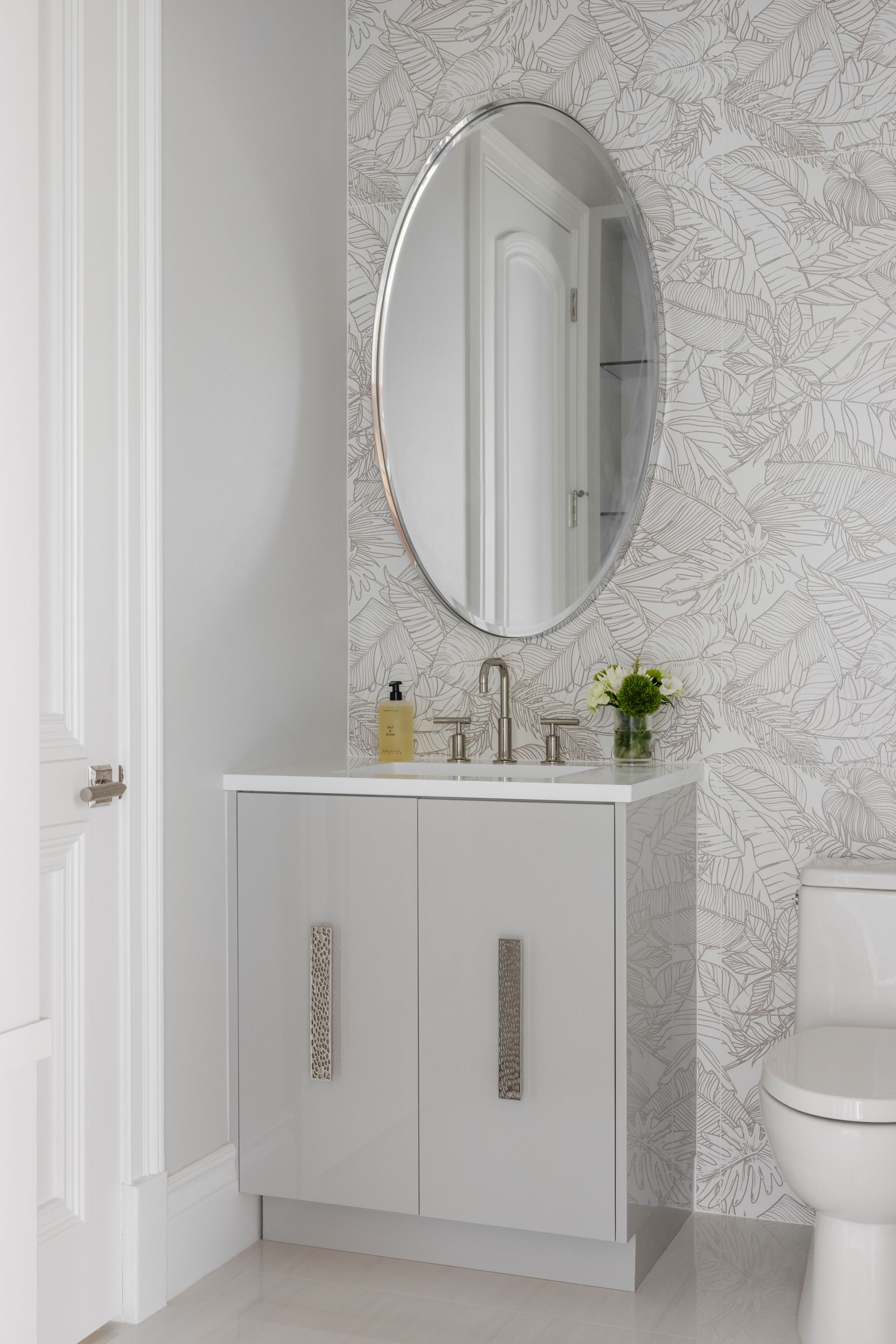 A bathroom with a sink, toilet and mirror.