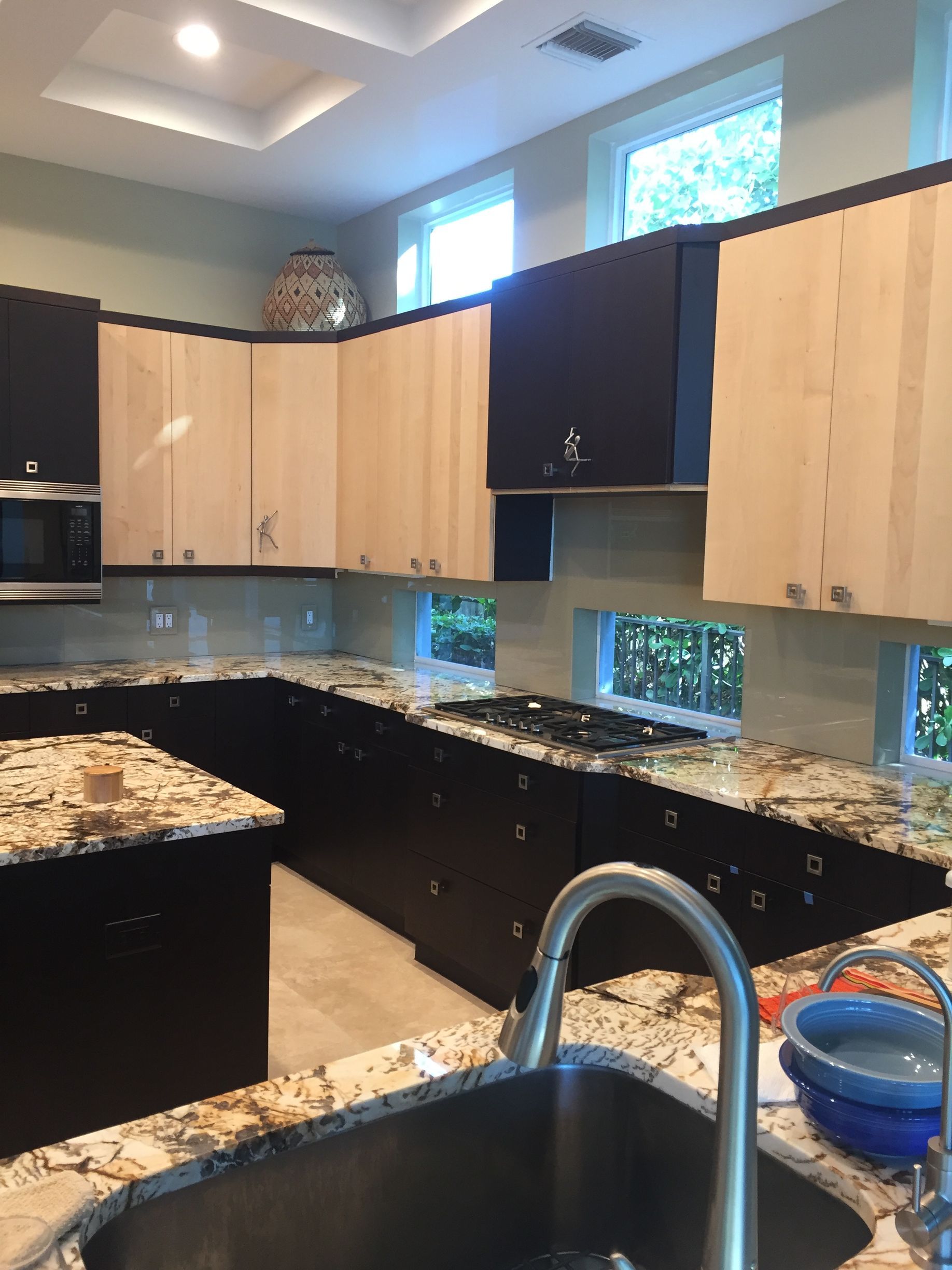 A kitchen with granite counter tops and black cabinets