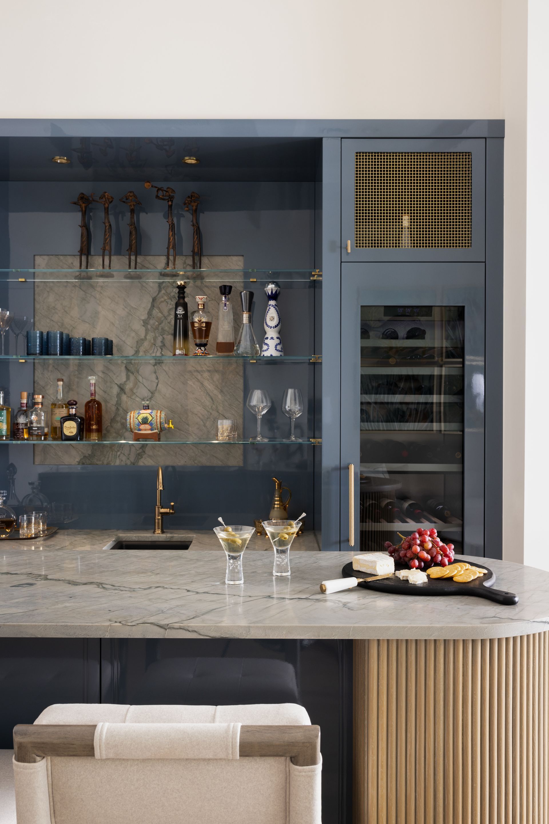A kitchen with a bar and a wine fridge.