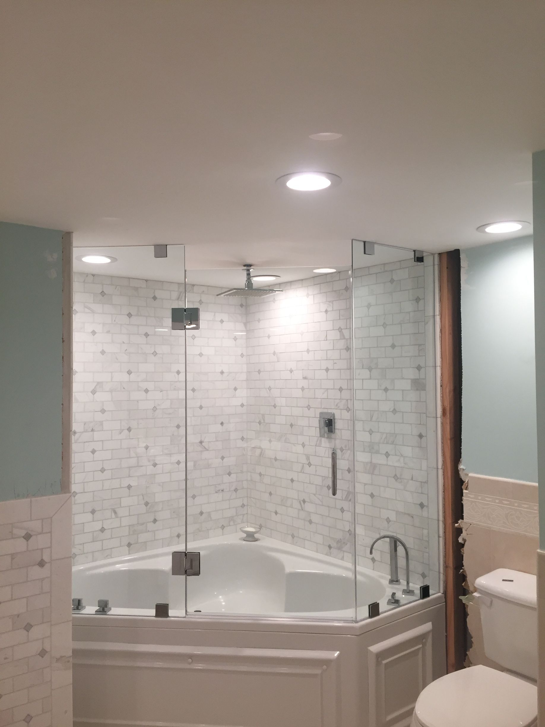 A bathroom with a tub, toilet and shower.