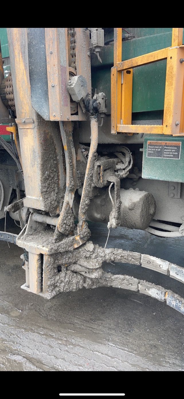 Mud-covered machinery, likely on a truck, with yellow safety structures visible.