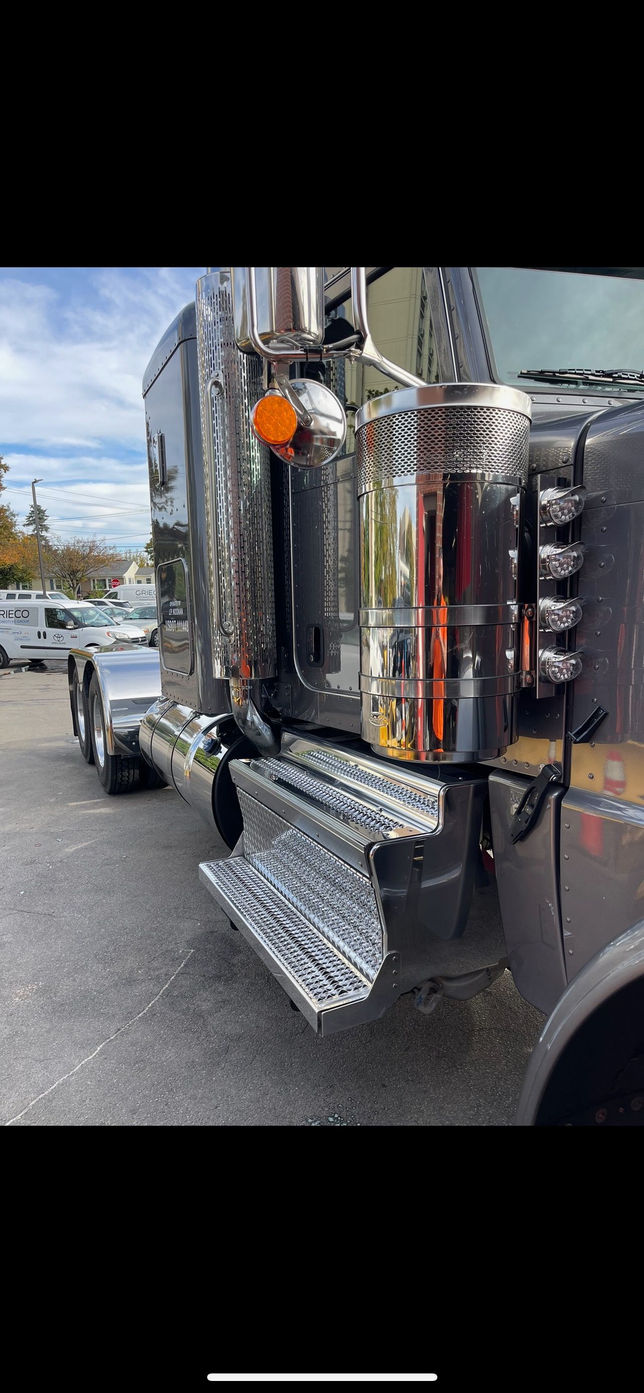 Chrome semi-truck, parked outdoors on a cloudy day.