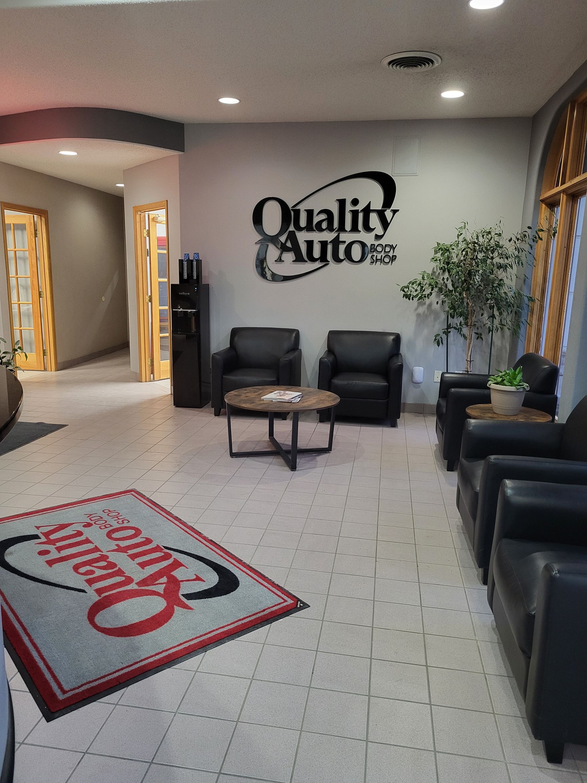 A lobby room with a sign that says Quality Auto Body Shop