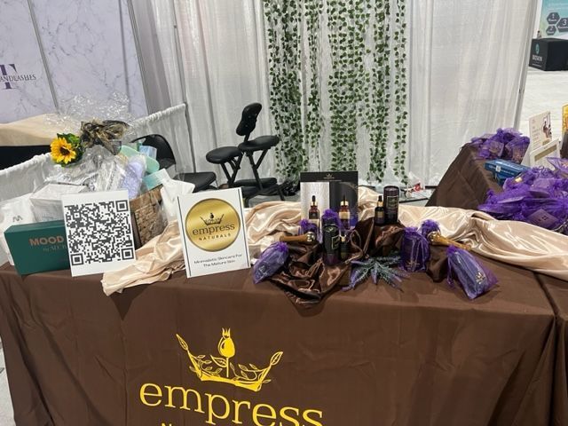 A booth with products and a massage chair at the Empress Organics stand.