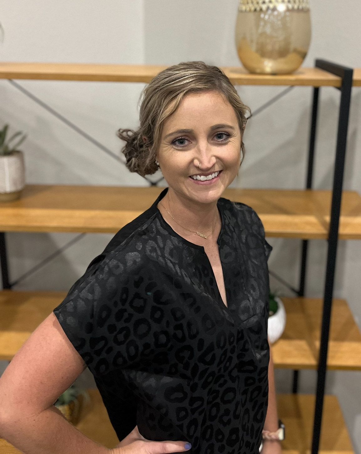 Woman in black shirt standing in front of shelf