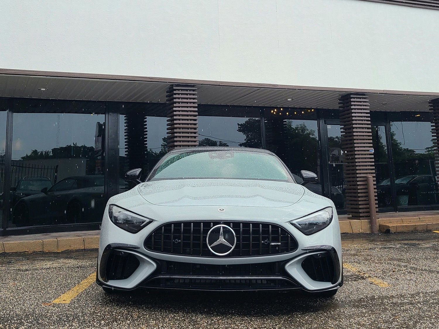 A white mercedes is parked in front of a building.