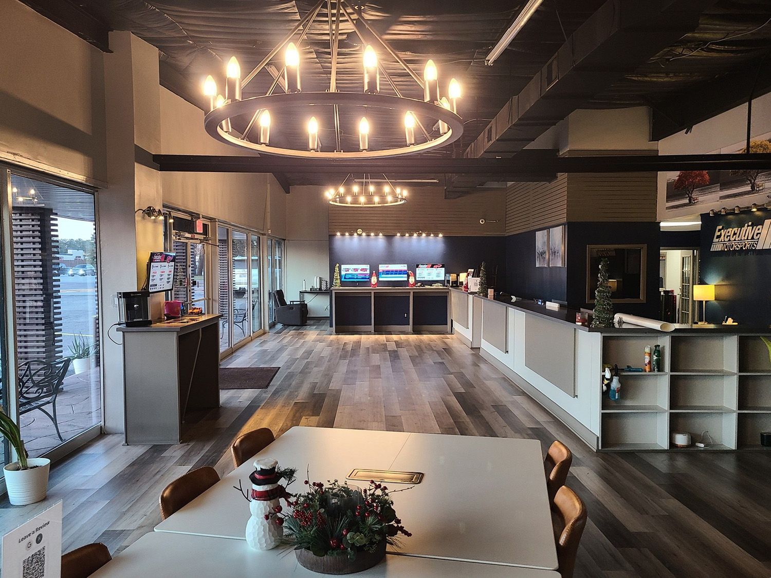 A large room with a table and chairs and a chandelier hanging from the ceiling.