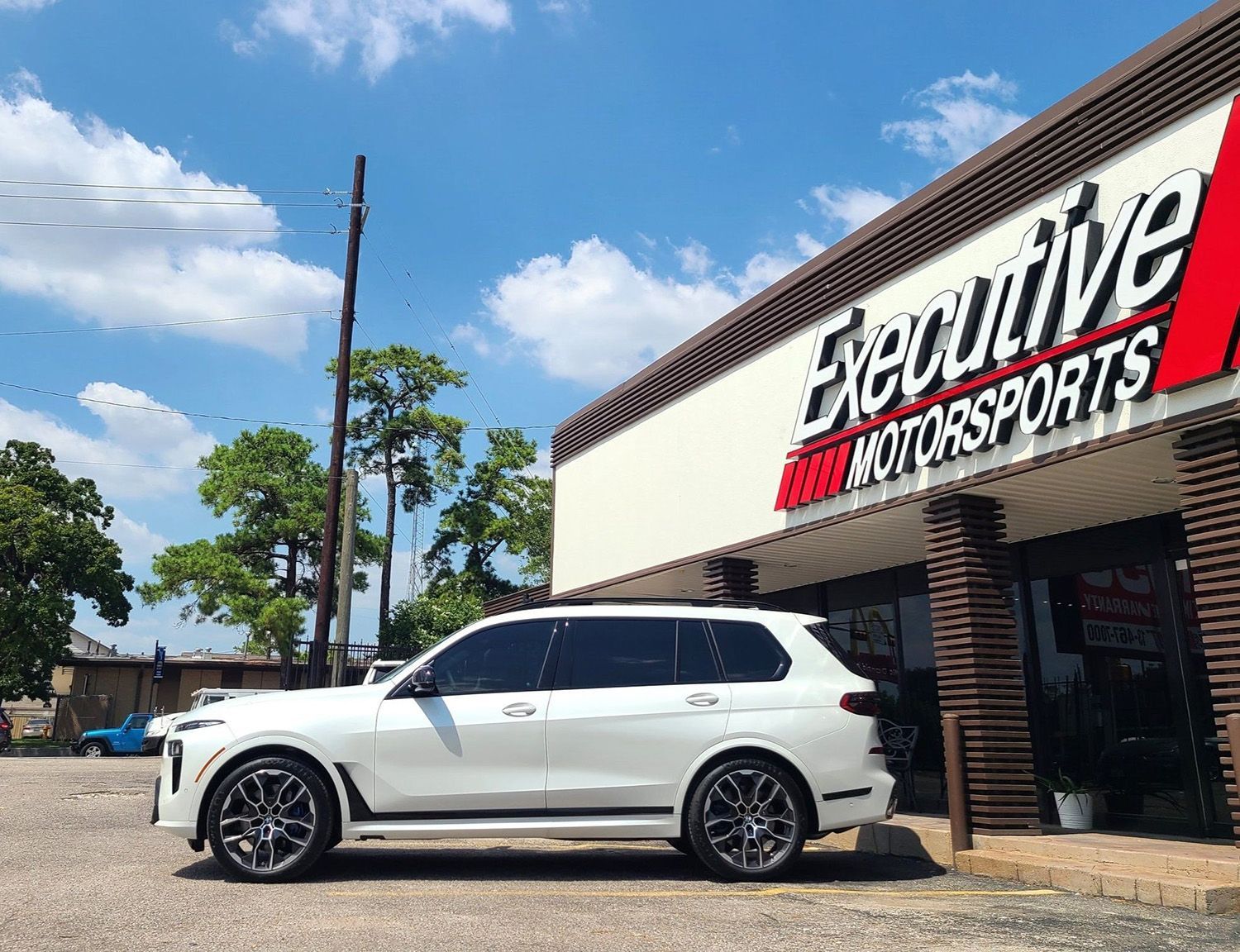 A white suv is parked in front of a building.