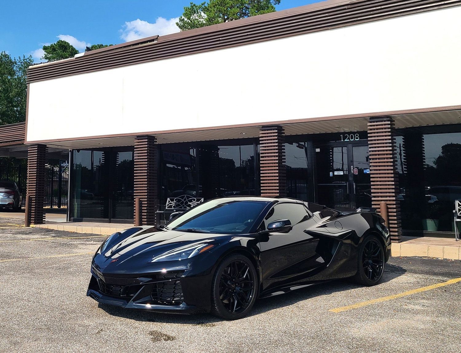 A black sports car is parked in front of a building.