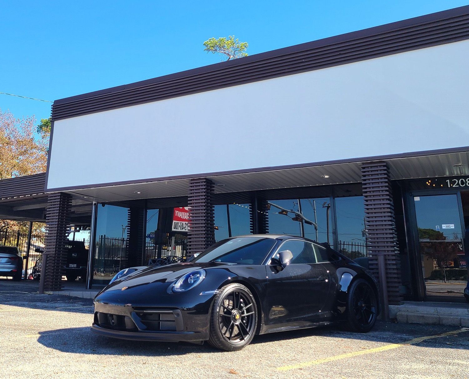 A black sports car is parked in front of a building.