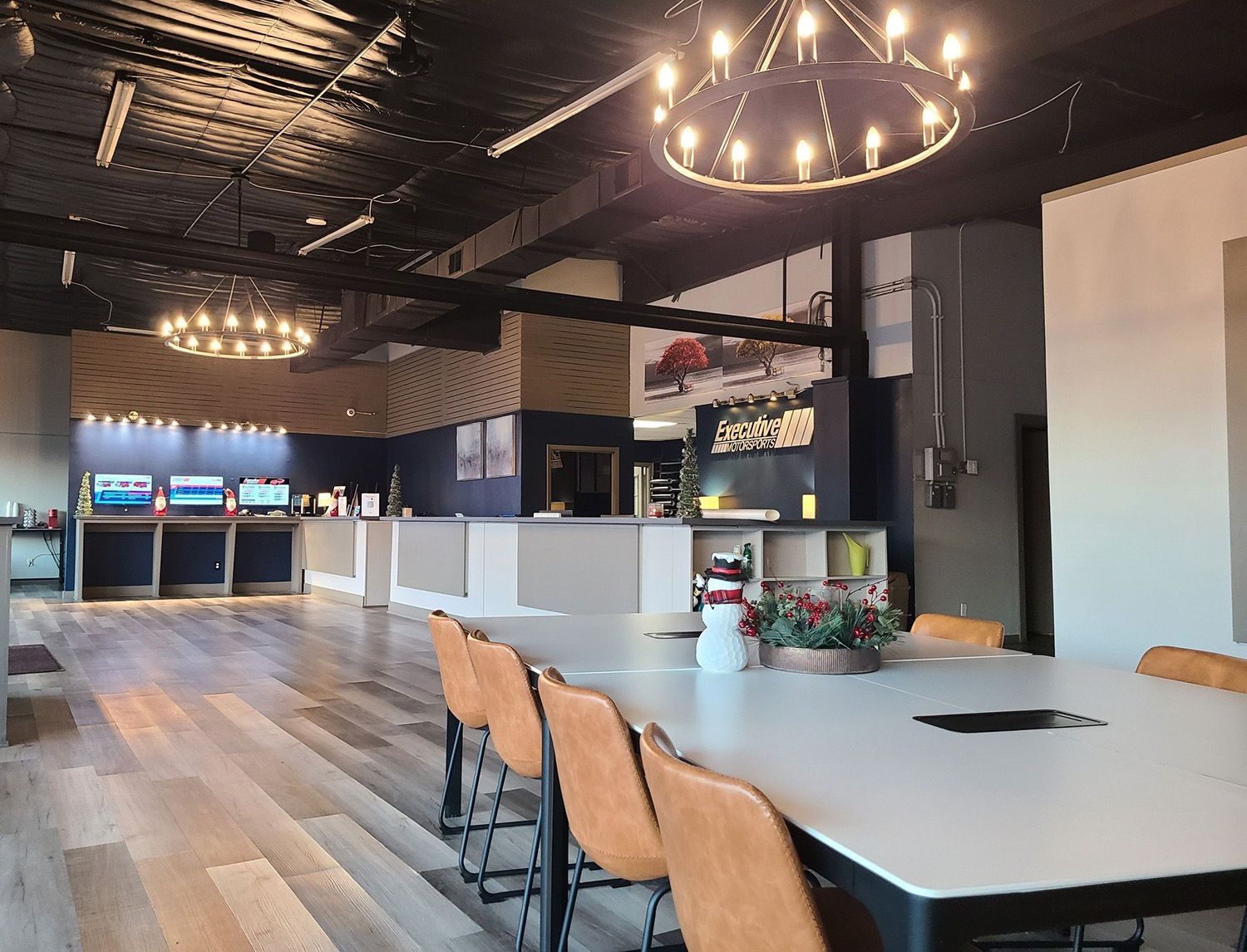 A large room with a table and chairs and a chandelier hanging from the ceiling.