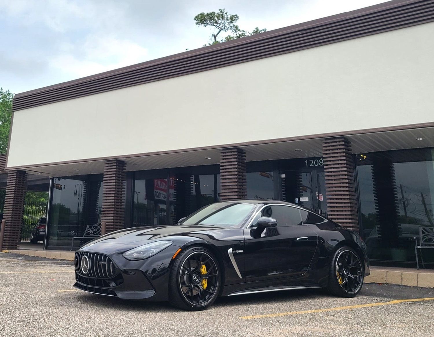 A black sports car is parked in front of a building.