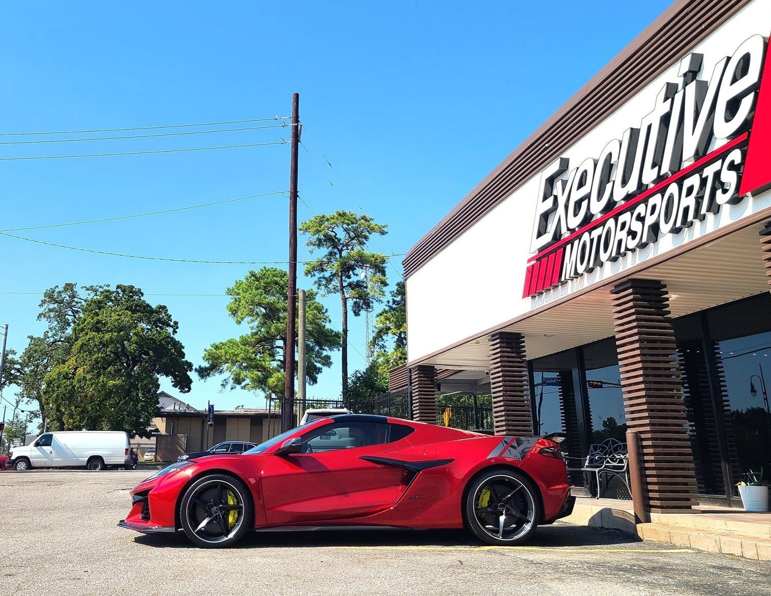 A red sports car is parked in front of a shop