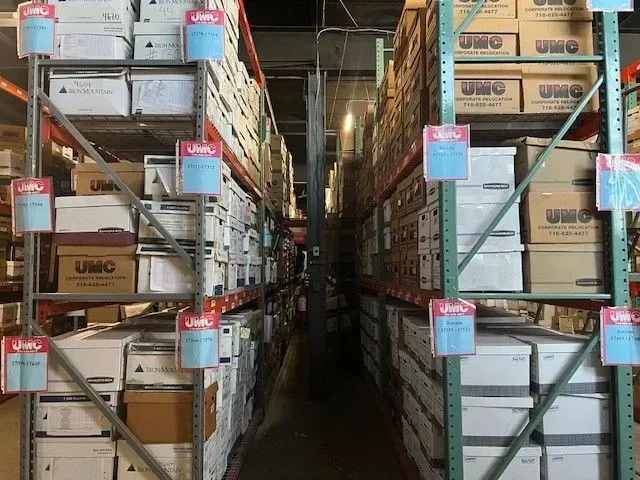 Aisle between tall warehouse shelves stacked with boxed inventory and bins