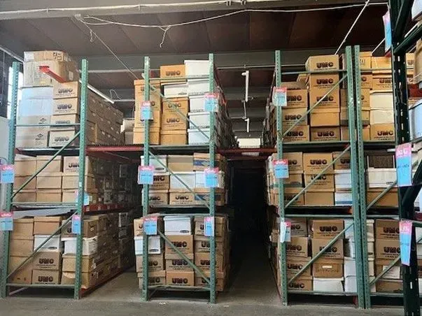 Warehouse shelves stacked with cardboard boxes and crates in storage aisle