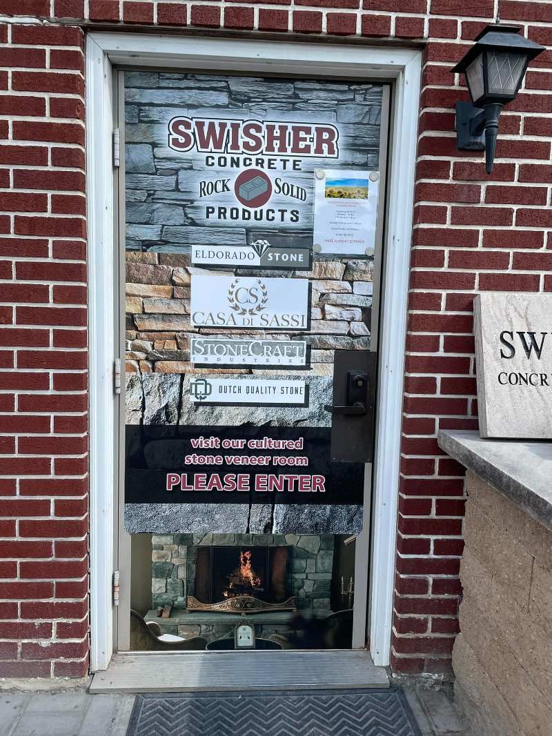 A brick building with a door that is covered in stickers.